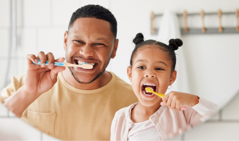 Man and young girl brushing their teeth